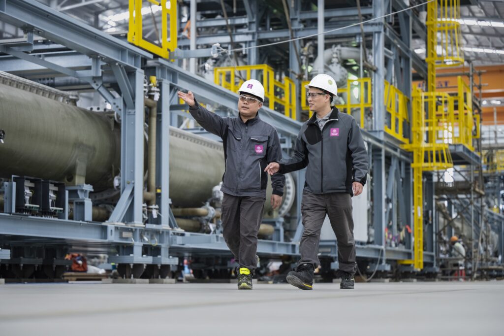 two employees walking in electrolyzer hall