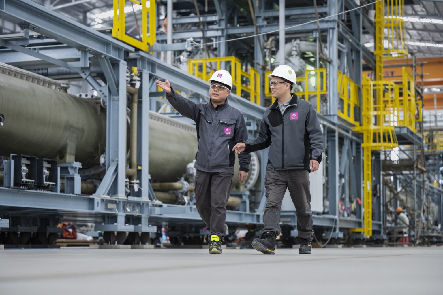 two employees walking in electrolyzer hall